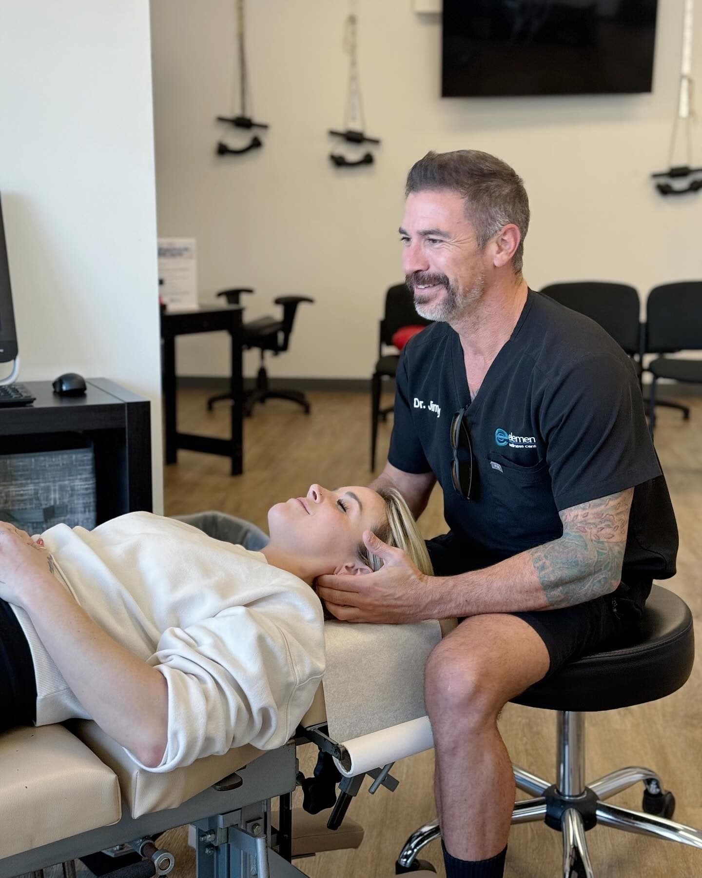 Dr. Jimmy Lopez performing a seated cervical adjustment on a patient at Element Wellness Center in Point Loma