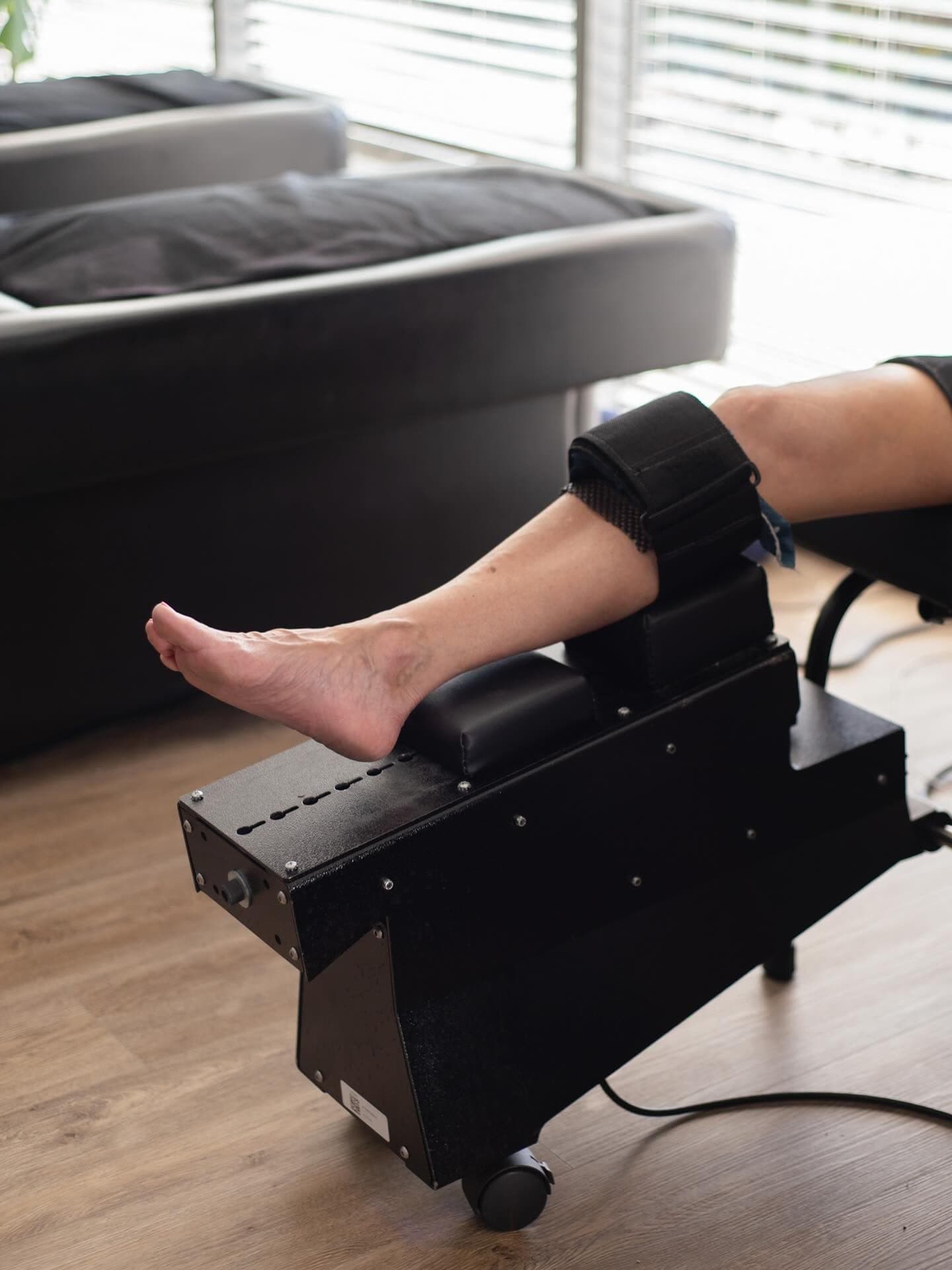 A patient’s leg secured in a mechanical knee decompression device during a session at Element Wellness Center