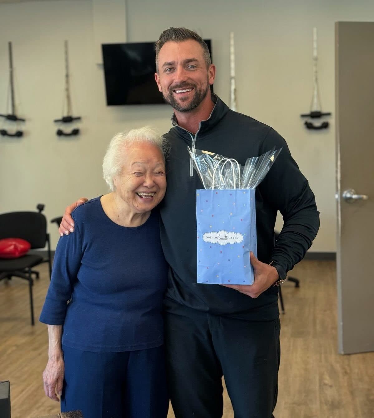 A smiling patient with a member of the Element Wellness Center team