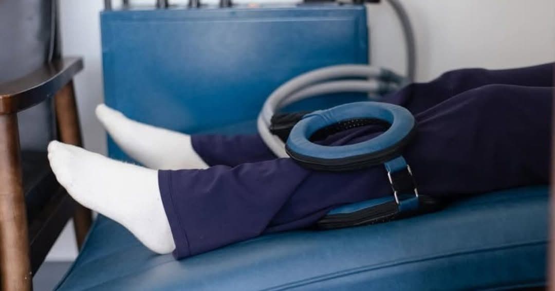 A patient receiving PEMF therapy with an electromagnetic coil positioned over the knee